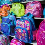Rayonnage de magasin coloré présentant une large sélection de sacs à dos scolaires pour enfants, idéal pour trouver un cartable Minnie et ses amies primaire.