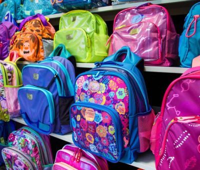 Rayonnage de magasin coloré présentant une large sélection de sacs à dos scolaires pour enfants, idéal pour trouver un cartable Minnie et ses amies primaire.
