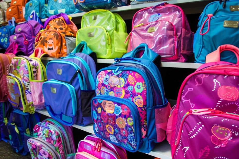 Rayonnage de magasin coloré présentant une large sélection de sacs à dos scolaires pour enfants, idéal pour trouver un cartable Minnie et ses amies primaire.