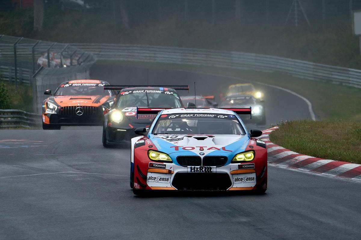 Plusieurs voitures de sport pilotées sur un circuit routier mouillé par la pluie Plusieurs voitures de sport pilotées sur un circuit routier mouillé par la pluie