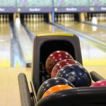 plusieurs boules colorées dans le distributeur de bowling