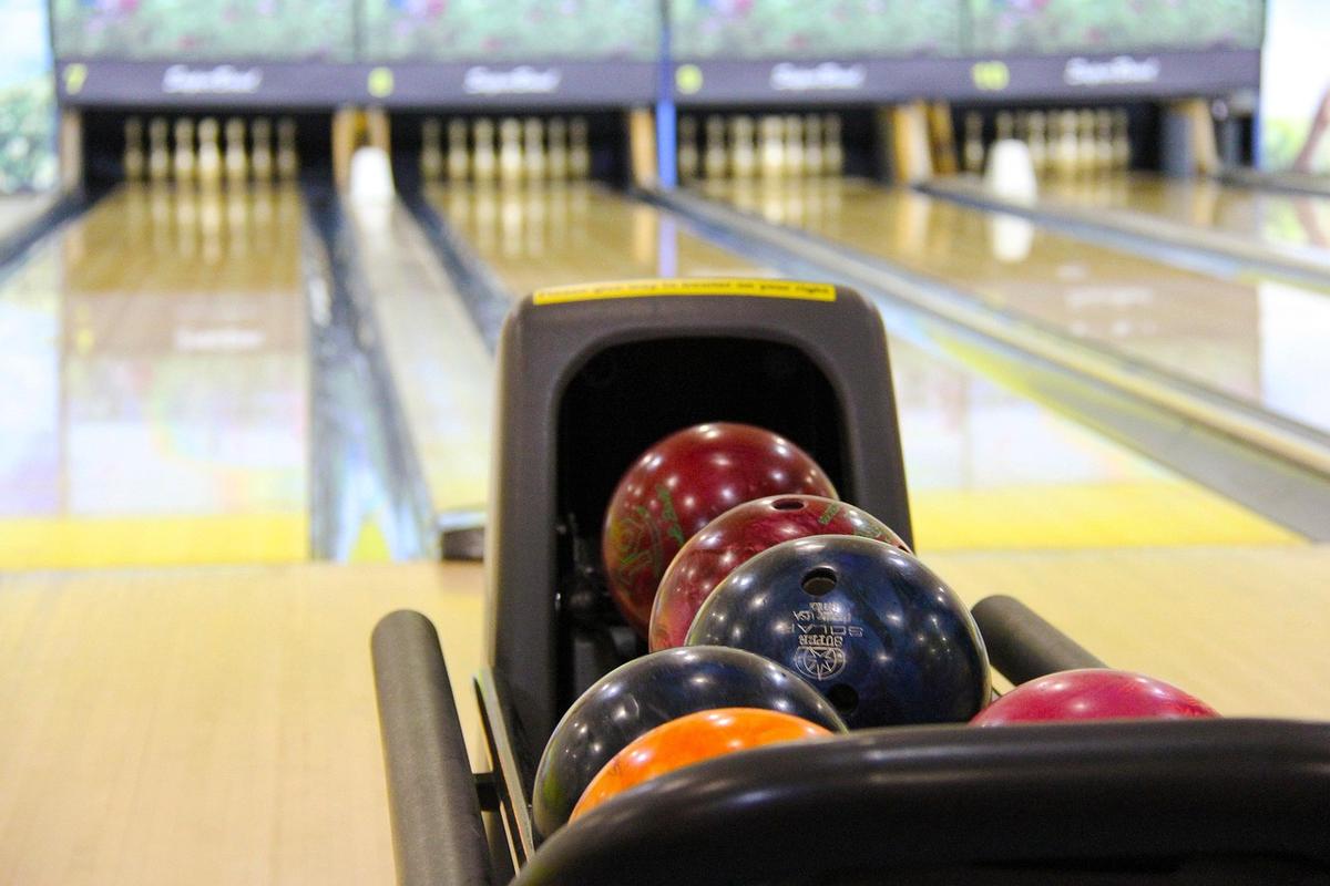 plusieurs boules colorées dans le distributeur de bowling