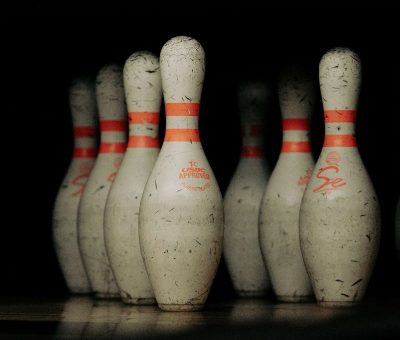 Des quilles de bowling blanches avec bandes orange sur fond noir