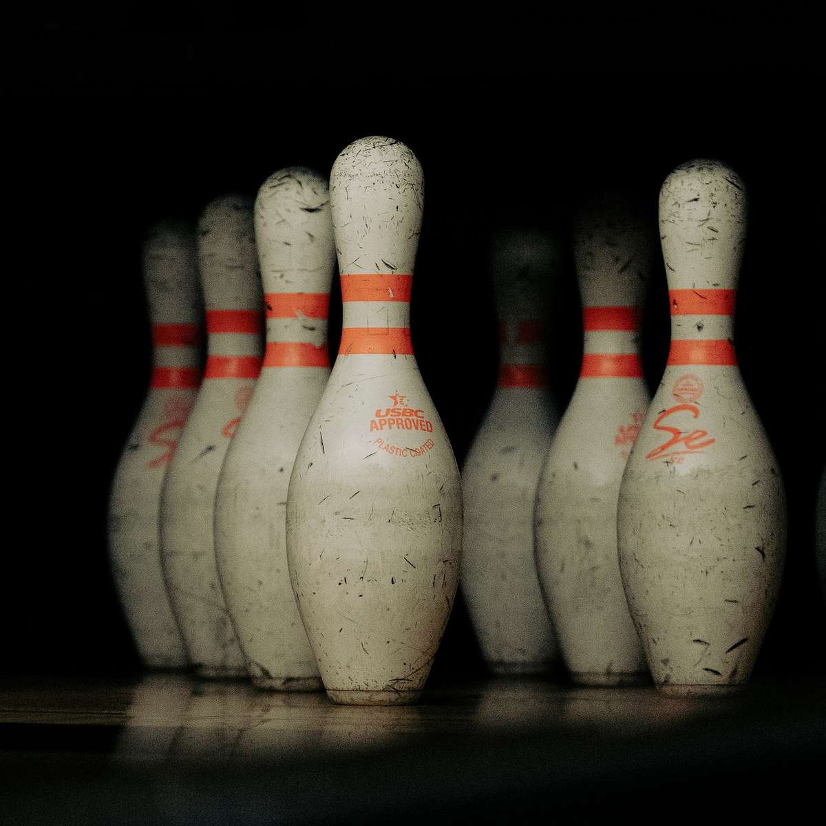 Des quilles de bowling blanches avec bandes orange sur fond noir