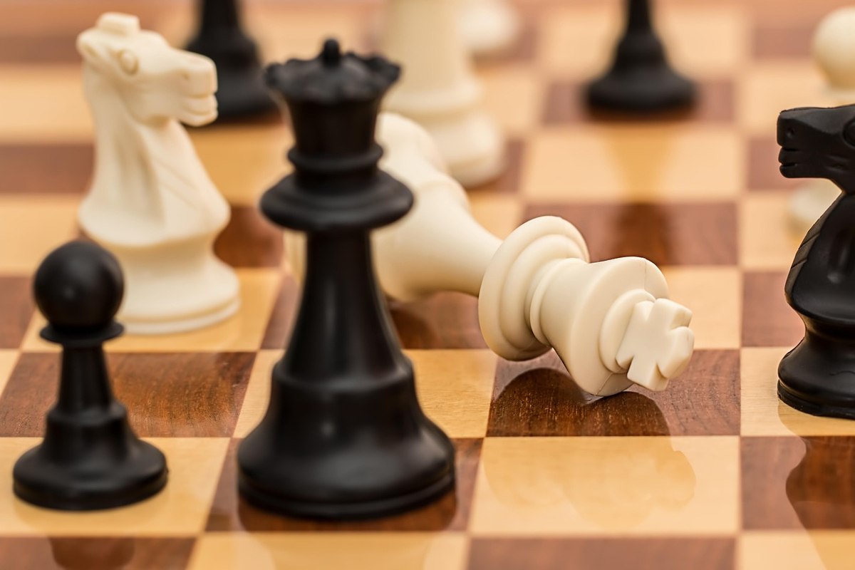 ALT: Une partie d'échecs avec une dame blanche renversée sur le plateau