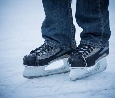 Un individu en jean porte des patins à glace sur la glace