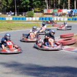 Des enfants pilotent des karts de course sur un circuit extérieur