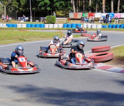 Des enfants pilotent des karts de course sur un circuit extérieur