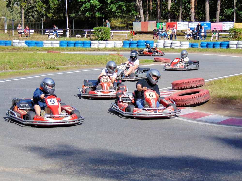 Des enfants pilotent des karts de course sur un circuit extérieur