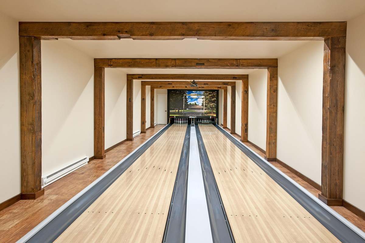 Deux allées de bowling en bois sous un plafond à poutres