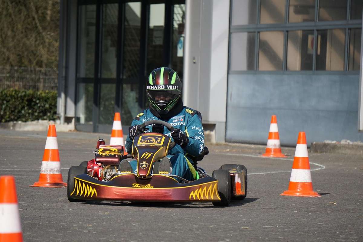 Un conducteur pilote un kart de course entre cônes orange
