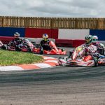 Plusieurs karts de course tournent en virage sur circuit