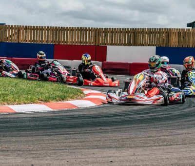 Plusieurs karts de course tournent en virage sur circuit