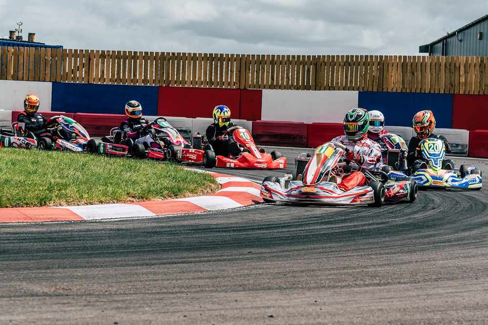 Plusieurs karts de course tournent en virage sur circuit