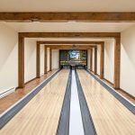 Allée intérieure de bowling avec pistes en bois et poutres apparentes